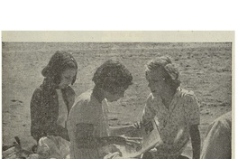 8. Un grupo de niñas lee y conversa en la playa.