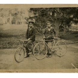 3. Dos niños con boinas, aparecen en la fotografía en bicicleta en el parque de la Quinta Normal.