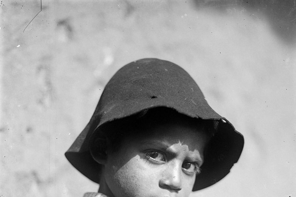 7. Niño con poncho y sombrero jugando con un runrún.