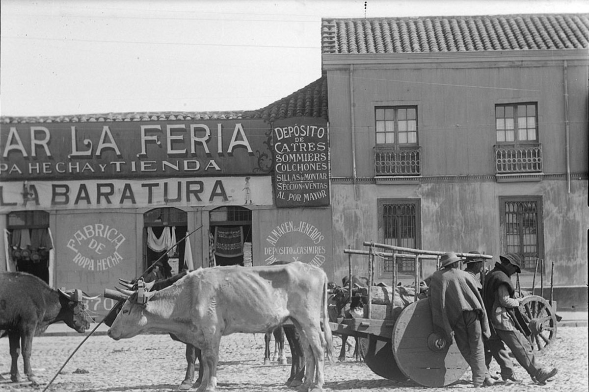 10. Tres hombres con sus animales de carga y carretas en la feria.