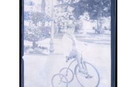 7. Niño en un triciclo en la plaza Vicuña Mackenna, al costado del cerro Santa Lucía. Año 1920.