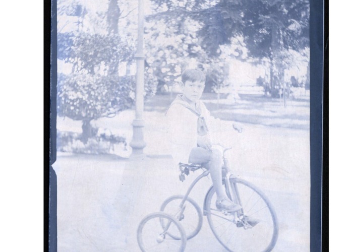 7. Niño en un triciclo en la plaza Vicuña Mackenna, al costado del cerro Santa Lucía. Año 1920.